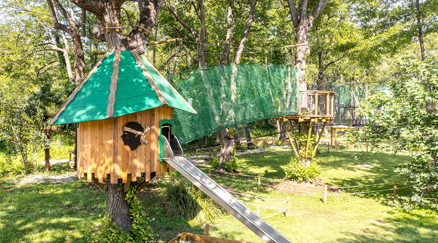 Accrobranche pour enfants dans un parc aventure verdoyant, harmonisant nature et divertissement sécurisé.