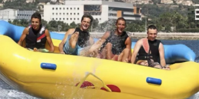Quatre amis partagent un moment d'adrénaline en jet-ski sur la mer, illustrant la joie et la camaraderie estivales.
