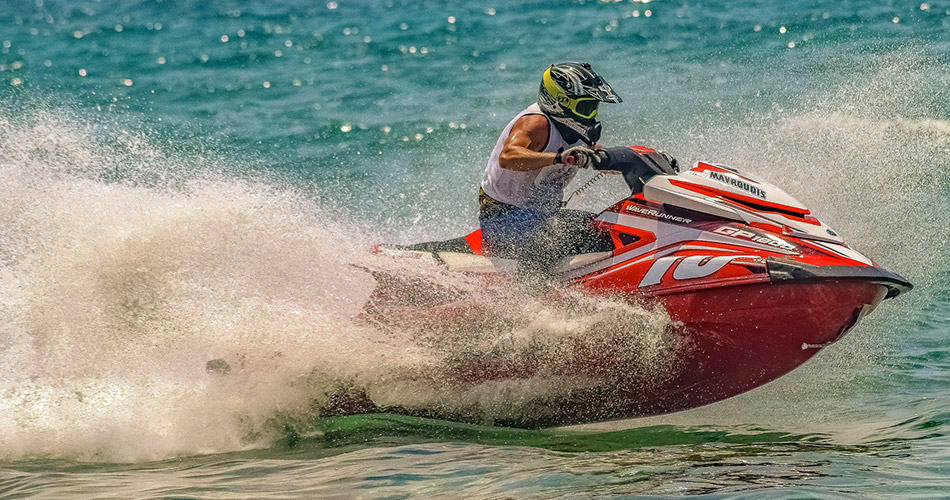 Un pilote de jetski effectue des acrobaties audacieuses sur une mer turquoise, mettant en avant l'énergie estivale et l'adrénaline des sports nautiques, parfait pour les amateurs de sensations fortes.