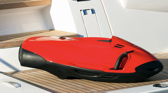 Le Seabob rouge, élégant et dynamique, trône sur le pont en bois d'un yacht, prêt pour l'aventure maritime.