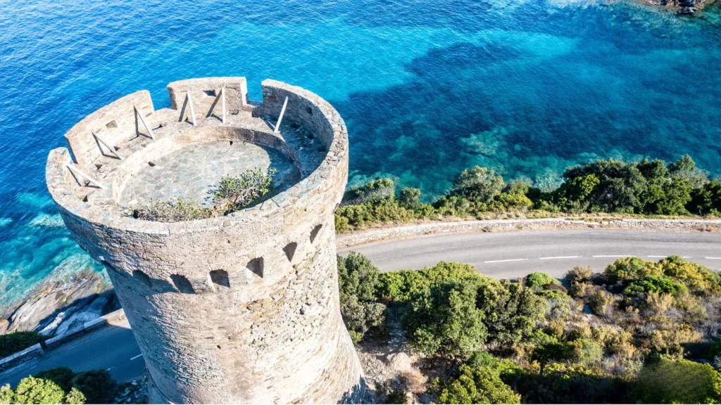 partenaire-corsica-camping-hpa-tour-genoise-littoral.webp Vue aérienne d'une tour génoise en Corse surplombant une mer turquoise, illustrant le potentiel touristique pour les futurs campings partenaires Corsica Camping.