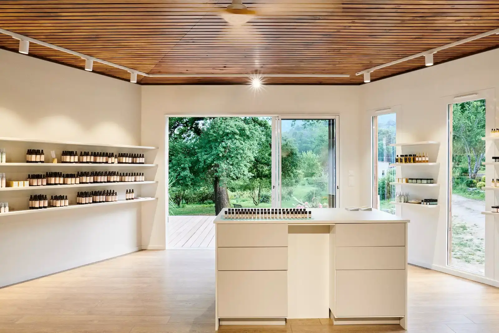 Intérieur lumineux de la boutique de cosmétiques bio avec vue sur jardin en Corse.