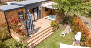 Lodge moderne en bois avec grande terrasse, jacuzzi privatif et jardin paysager au Camping Merendella.