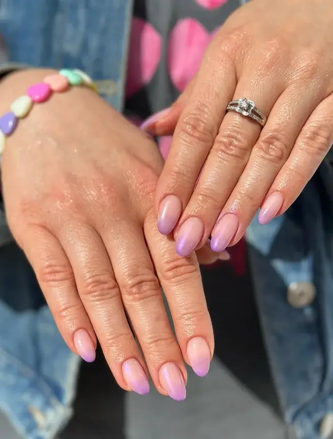 Pose d'ongles en gel forme amande avec un dégradé baby boomer violet et rose pastel.