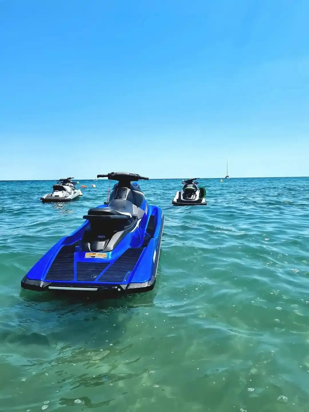 Jet ski bleu LS Location au mouillage sur les eaux cristallines de Moriani Plage en Haute-Corse.