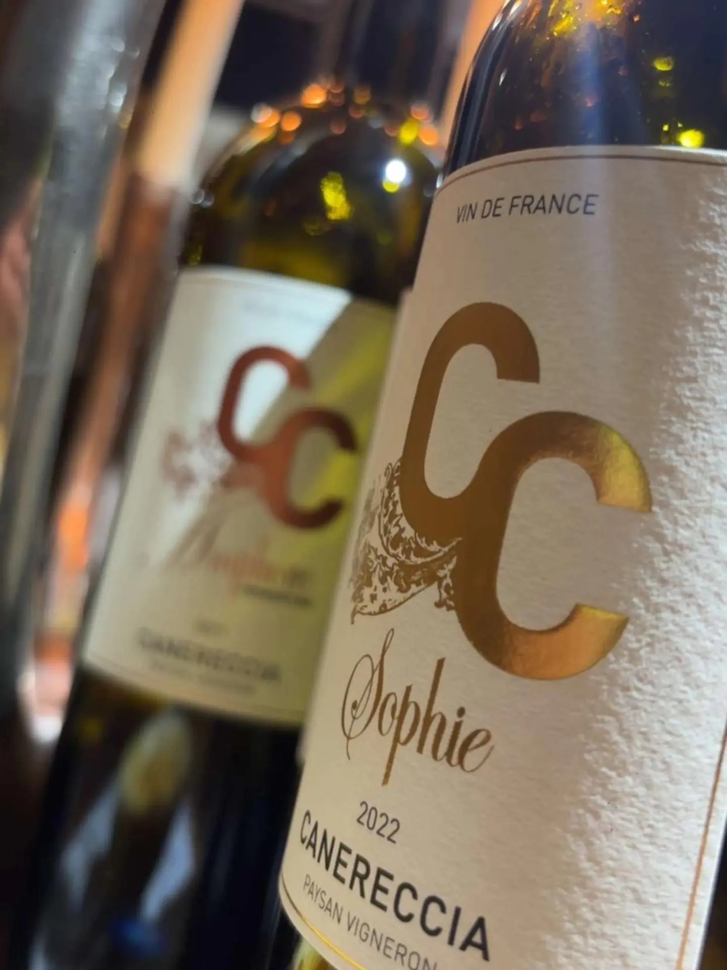 Zoom sur l'étiquette blanche à dorures d'une bouteille de vin Clos Canereccia cuvée Sophie millésime 2022.