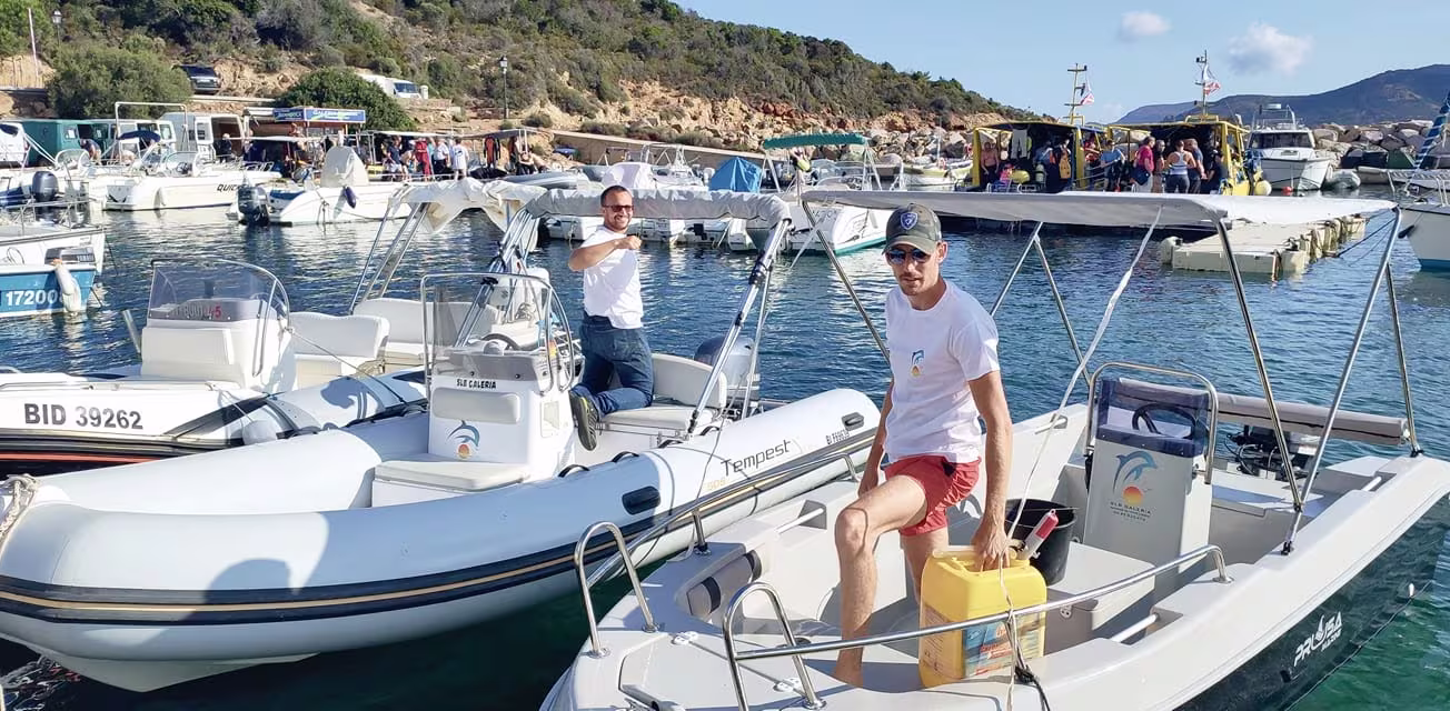 Équipe professionnelle de SLB Galéria préparant des bateaux à moteur et semi-rigides au port de Galéria pour une location.