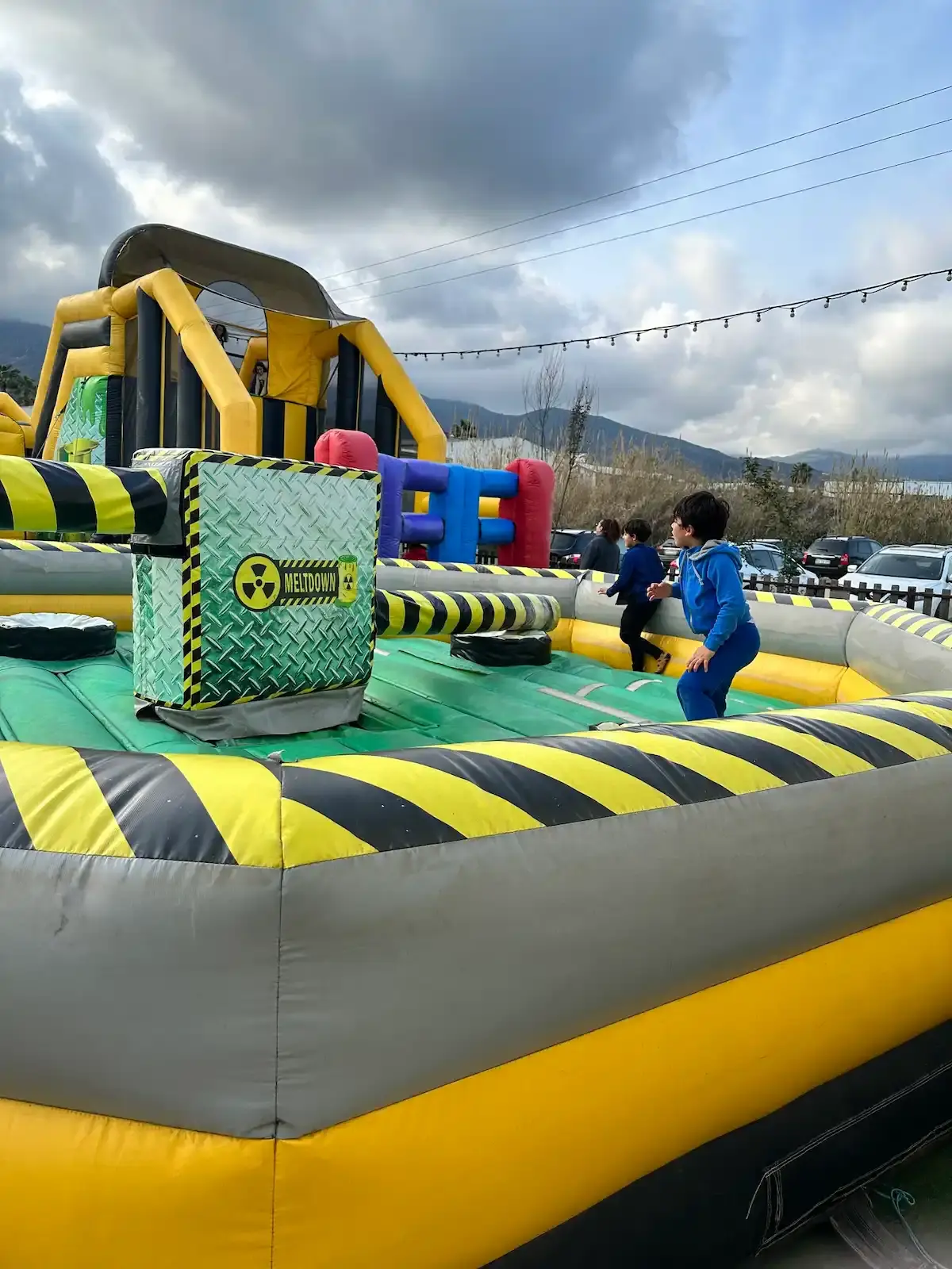Enfants jouant sur l'attraction Meltdown du Family Parc, une structure gonflable mécanique avec bras rotatifs en Haute-Corse.